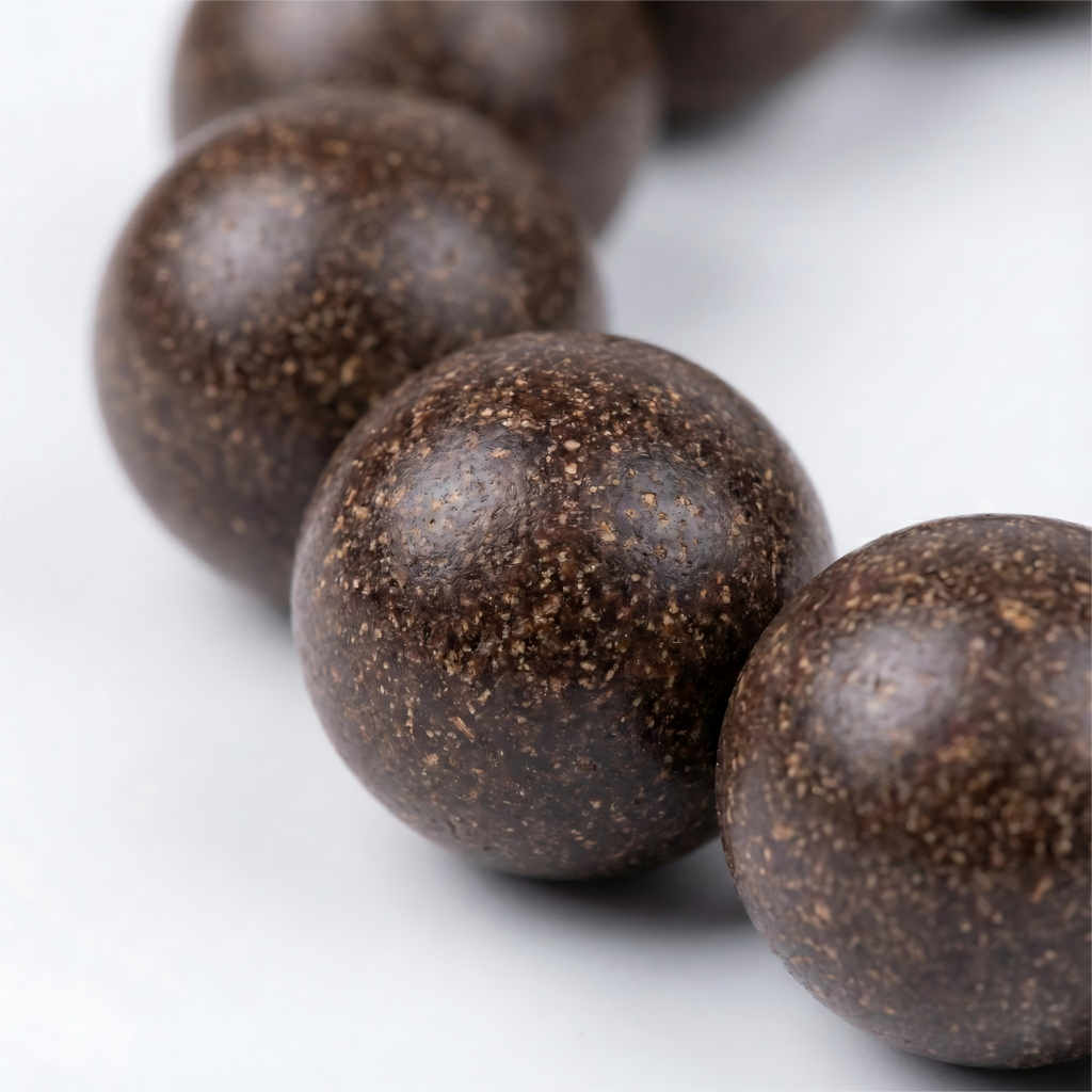 Macro close up of handmade dark herbal incense beads showing natural organic grain and matte texture without chemical glue.