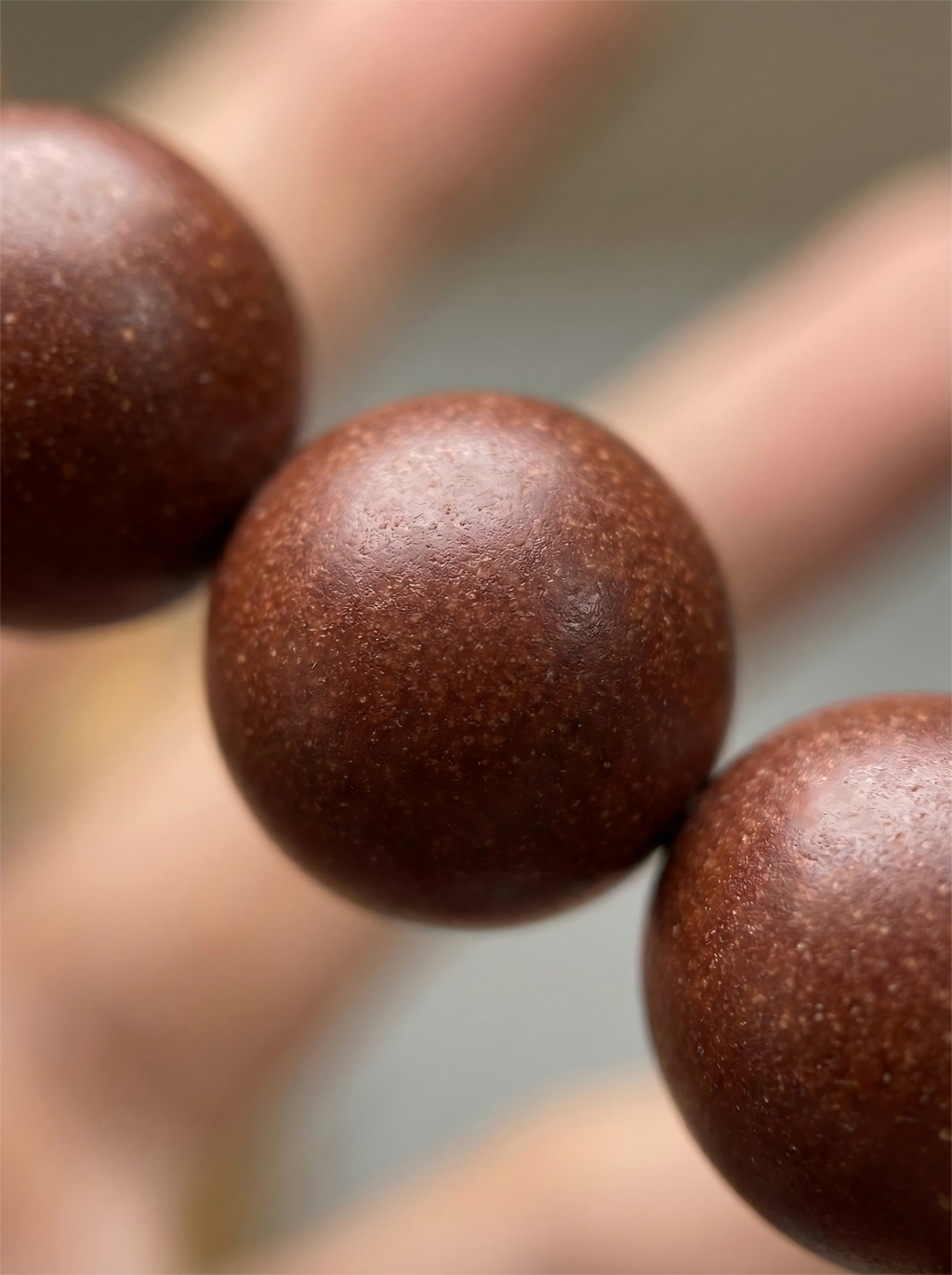 Macro close up of handmade crimson red herbal clay beads showing natural matte organic texture without chemical glue.